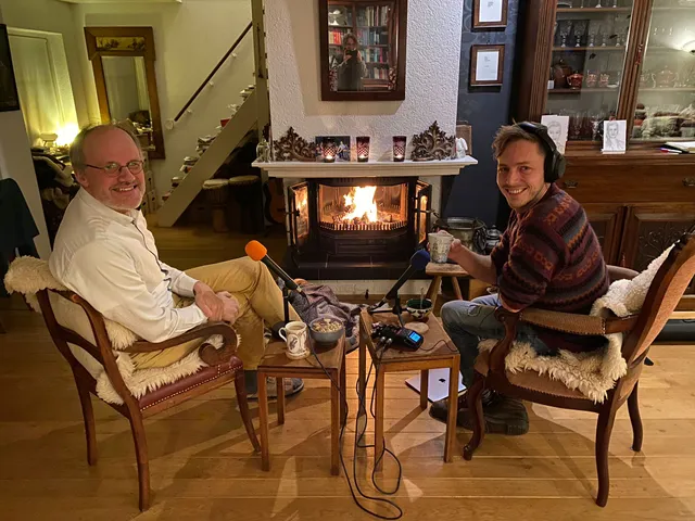 Evert-Jan Ouweneel en Elbert Smelt nemen de podcast Kerk en ik op zittend voor een openhaard.