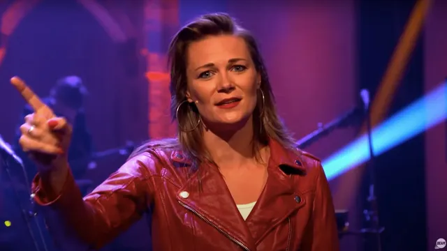 Nelinda spreekt de kijkers van de BEAM Kerkdienst toe. Ze kijkt in de camera en wijst met haar wijsvinger omhoog.