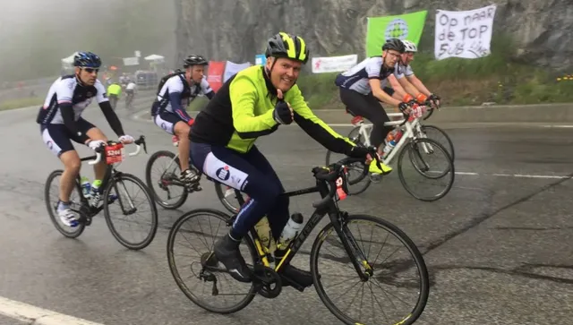 Weerman Marco Verhoef op racefiets met duim omhoog.